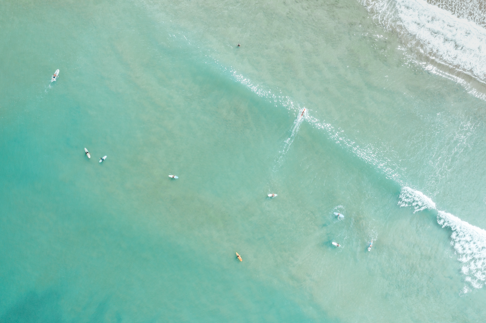 Surfers at Hanalei Bay Beach in Kauai via Find Us Lost