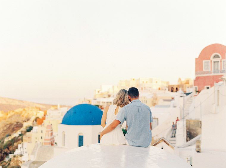 Couple overlooking Santorini Rooftops Enagement Session Oia Town