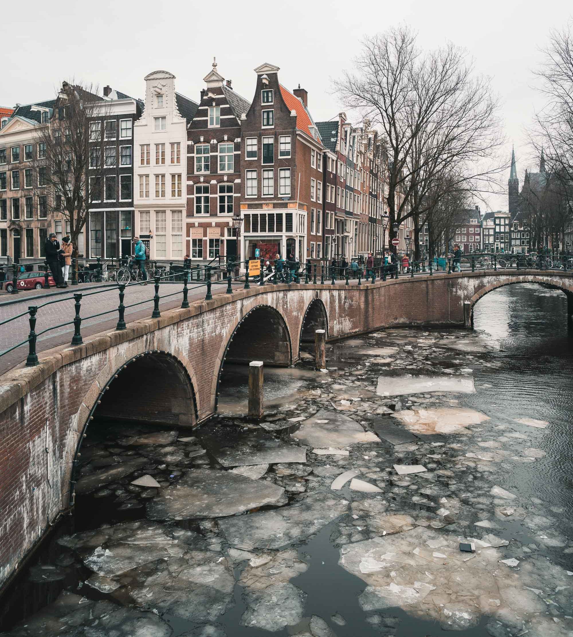 Semi-frozen canals with ice in winter at sunset in Amsterdam The Netherlands
