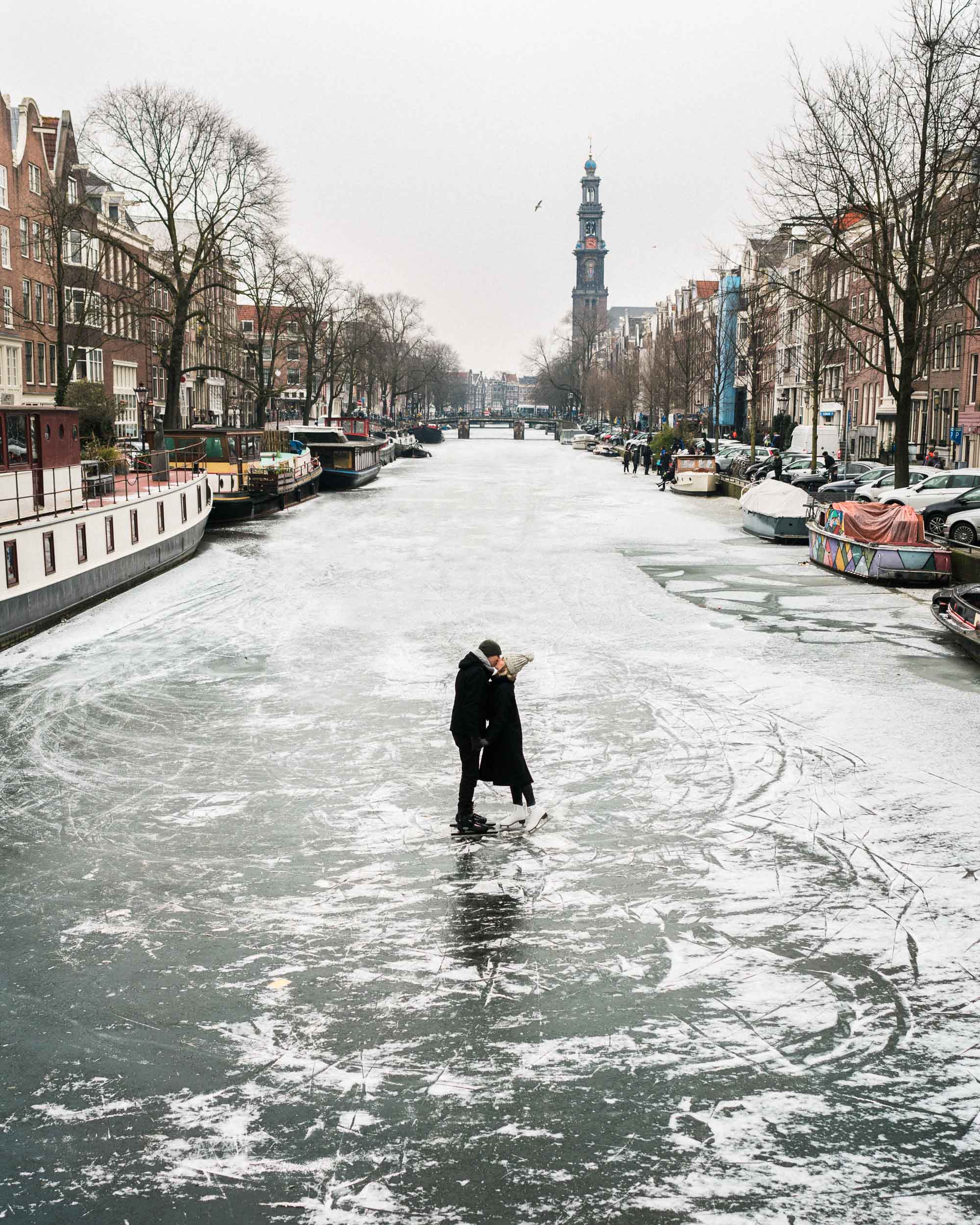 Travel bloggers Selena Taylor and Jacob Taylor ice skating on the frozen canals in Amsterdam The Netherlands
