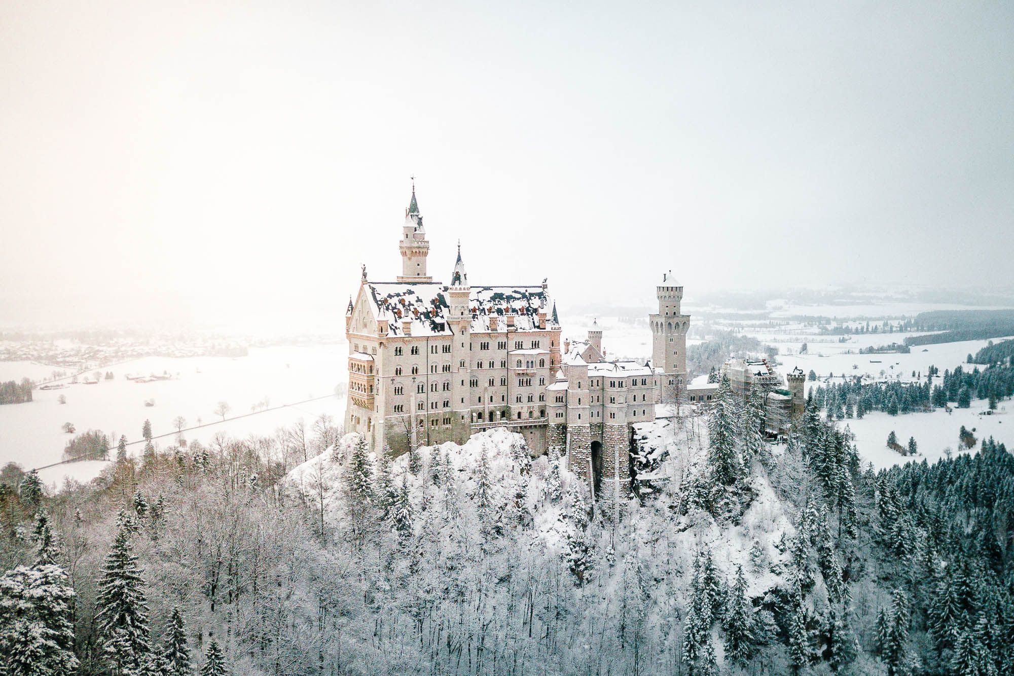 Neuschwanstein Castle in the snow in winter from mary's bridge Marienbrucke lookout best spot to photograph german fairytale castle