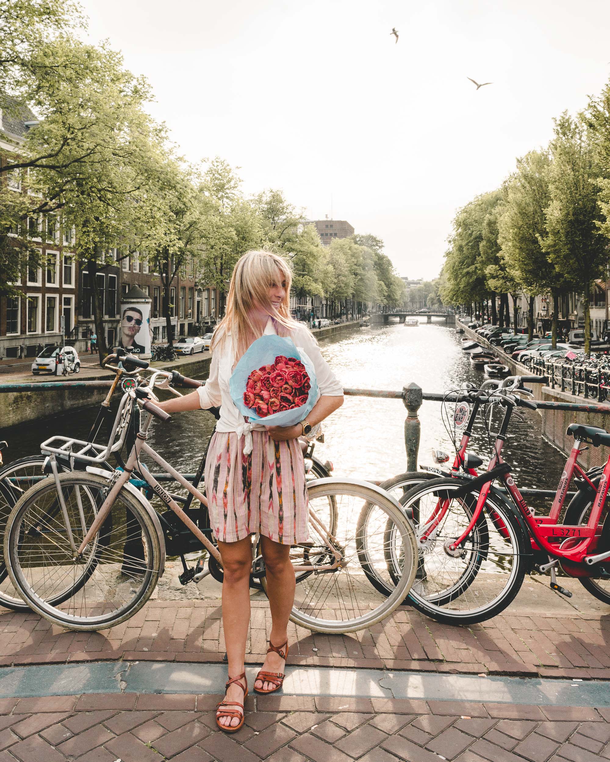 A girl with tulips and her bike on the canals in Amsterdam, The Netherlands
