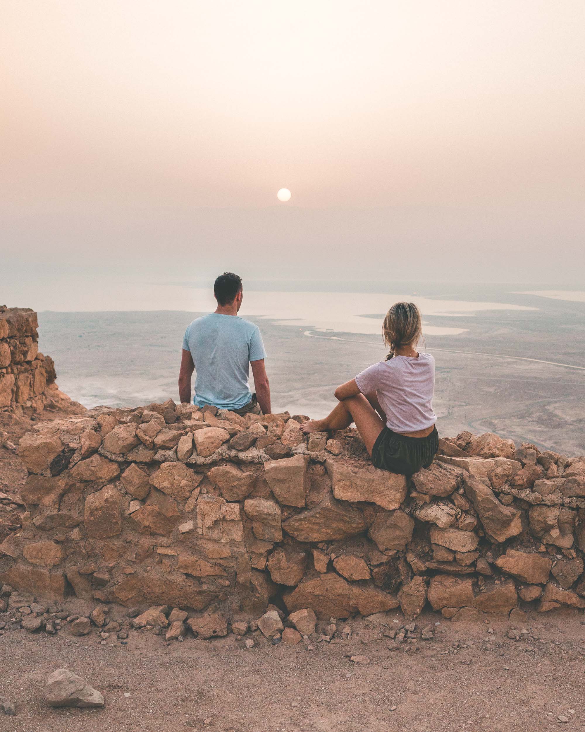 Couple watching sunrise over Masada hike in the dead sea in Israel