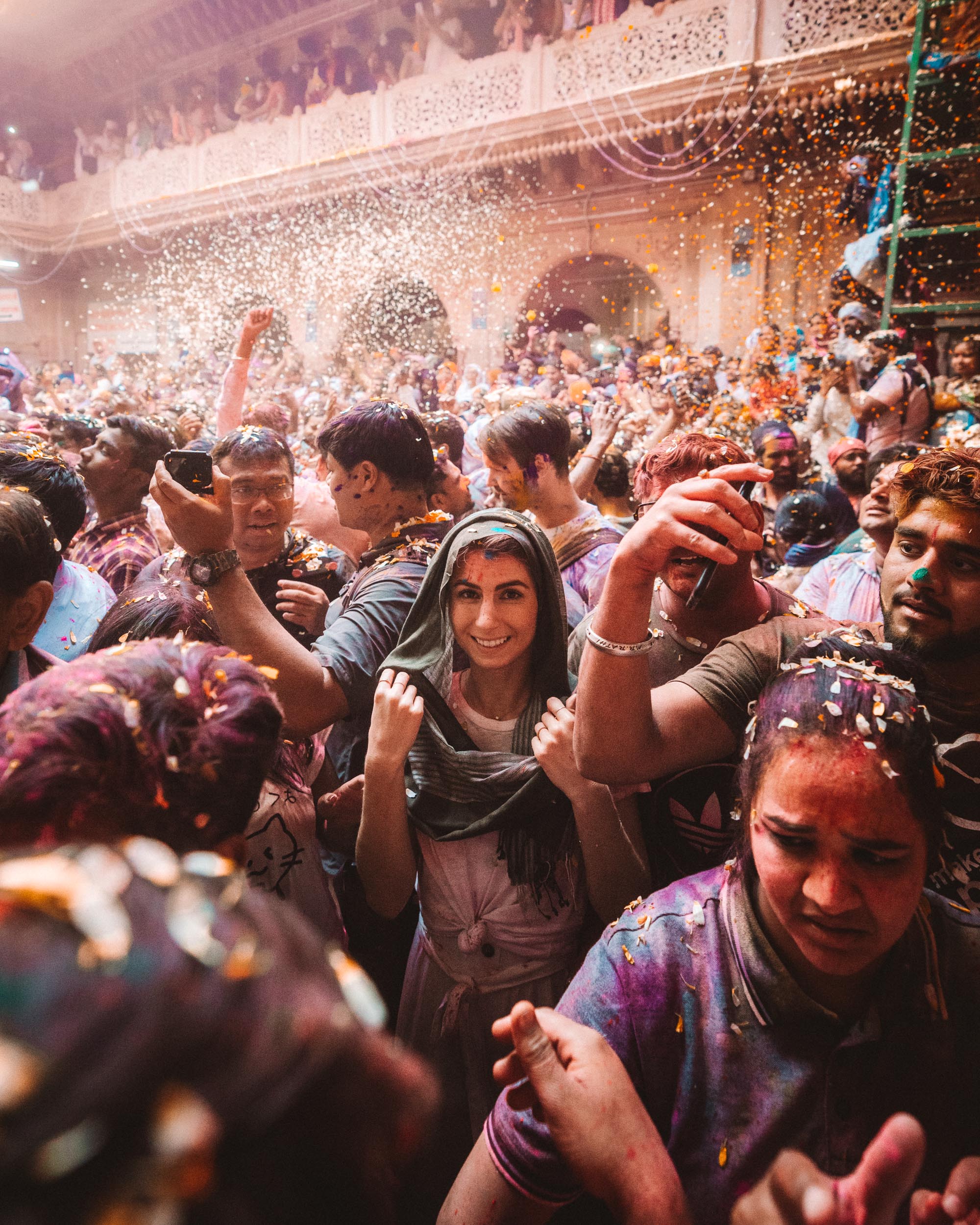 People celebrating with colorful powder and confetti during Pholoon Wali Holi Festival in Vrindavan, India via @finduslost