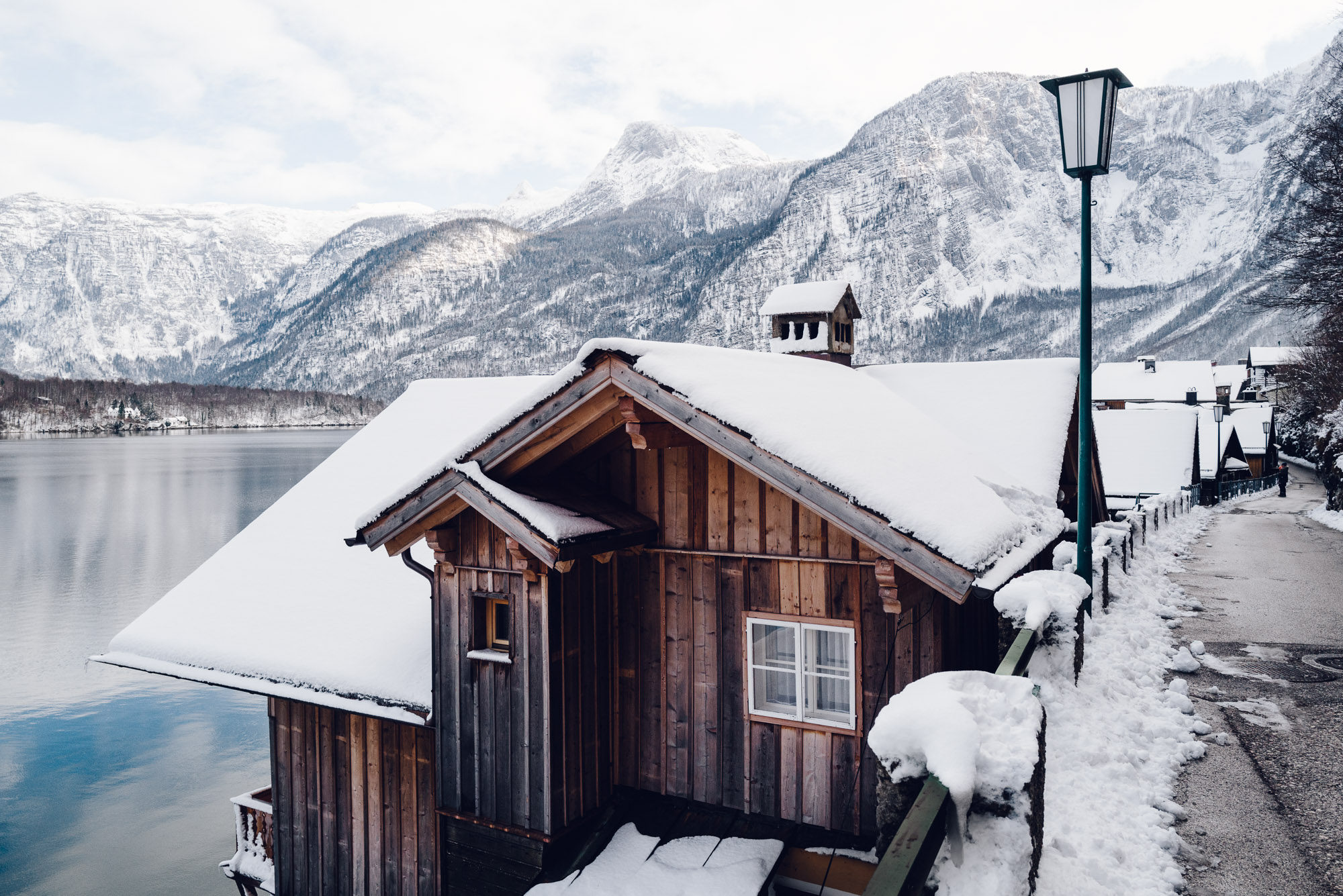 View of lake Hallstatt in winter from snow covered rooftops of houses
